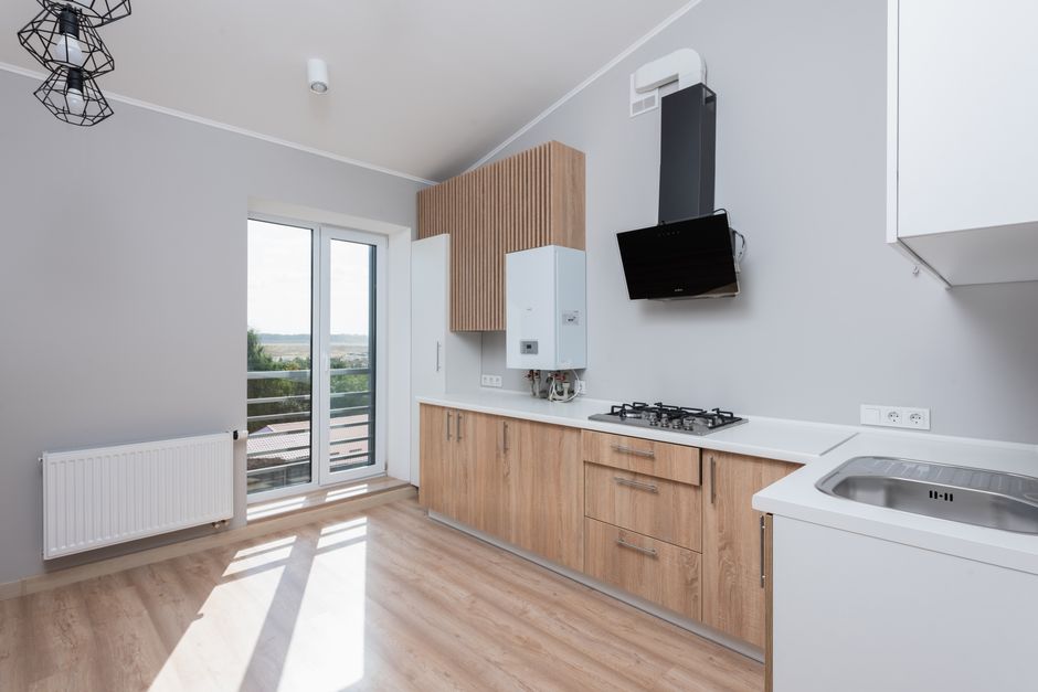 A kitchen lined with wall to wall cabinets, the kind of engineered wood surface that keeps offgassing formaldehyde years after installation.